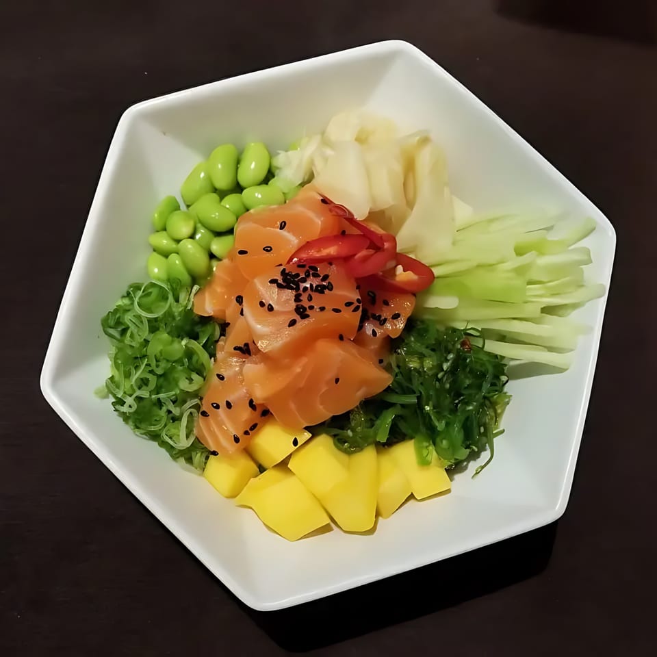 Blue Koi Sushi poke bowl with salmon, edamame, mango, seaweed, and pickled ginger.